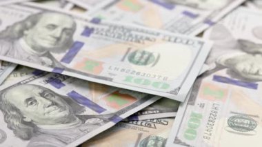 slowly roataing background of us dollar banknotes scattered on flat surface