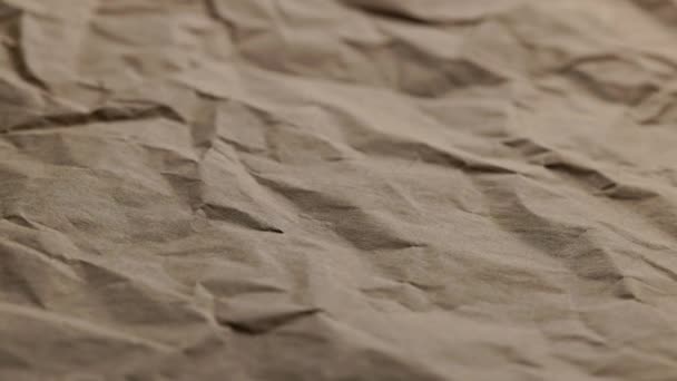 Looped spinning close-up full-frame background of crumpled brown craft paper — Wideo stockowe