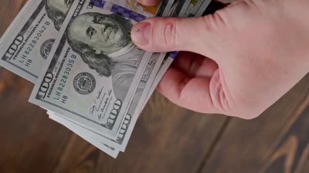 Καυκάσιος χέρι καταμέτρηση μικρή στοίβα των εκατό δολαρίων ΗΠΑ χαρτονομίσματα — Αρχείο Βίντεο