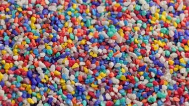 crushed colored stones on flat surface, slowly spinning, loopable closeup