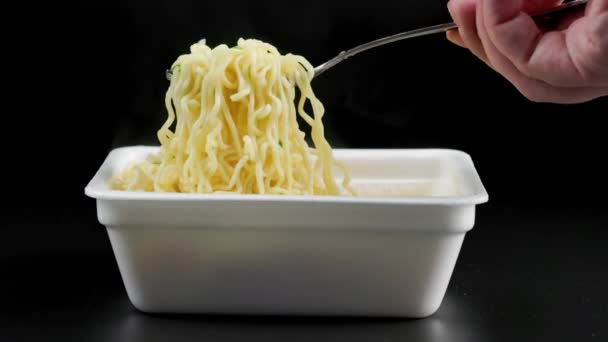 Hand with fork taking, holding and putting back cooked instant noodles — Vídeos de Stock