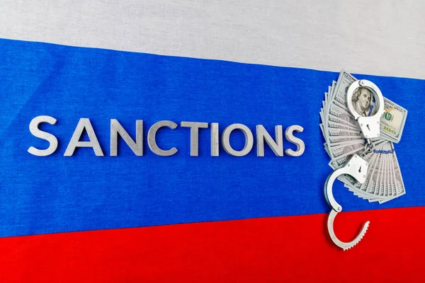 ロシアの三色旗に銀の金属文字で書かれた制裁という言葉は — ストック写真