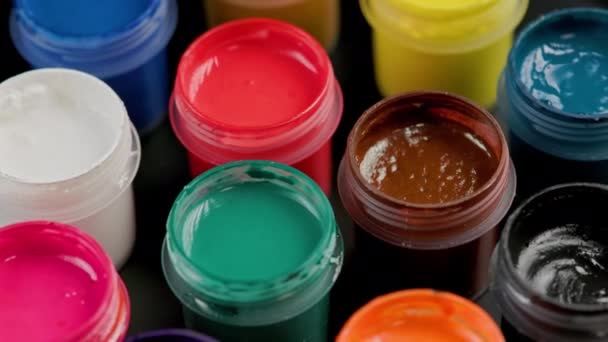 Loopable rotating close-up background of opened small gouache paint jars — Stok video