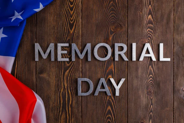 Anma günü, ahşap tahta yüzeyinde buruşuk Amerikan bayrağıyla gümüş metal harflerle yazılıydı.