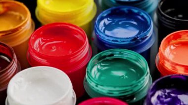 loopable rotating close-up background of opened small gouache paint jars