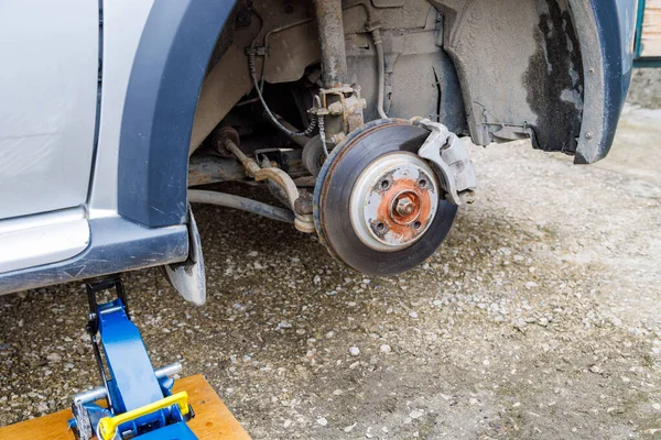 the hub of the front wheel of a jacked car during a tire change
