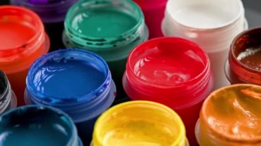 loopable rotating close-up background of opened small gouache paint jars