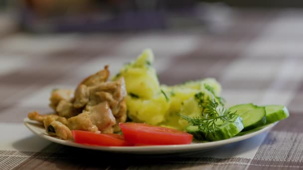 Hot steamy boiled potatoes and roasted chicken meat on white plate with vegetables — Video Stock
