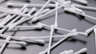 pile of q-tips or cottom buds slowly rotating on black background