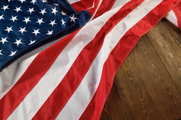 Bandera de EE.UU. arrugada sobre fondo plano de superficie de madera texturizada — Foto de Stock