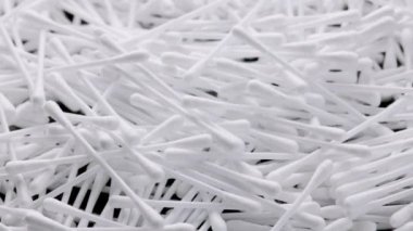 pile of q-tips or cottom buds slowly rotating on black background