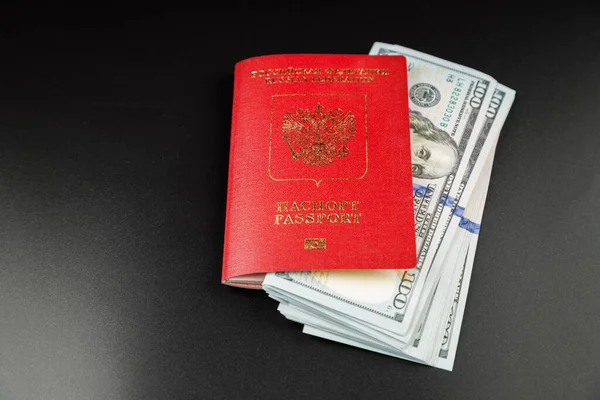 黒の背景に米ドルを挿入したロシアの国際パスポート — ストック写真