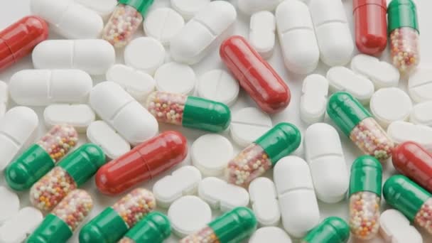 Berbagai jenis obat-obatan dan kapsul berputar pada permukaan putih — Stok Video