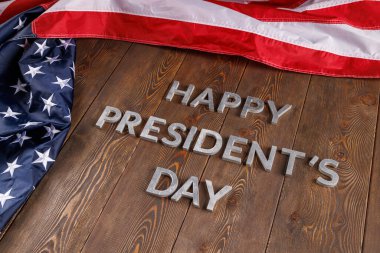 words happy presitdents day laid with real letters on wooden board near US flag