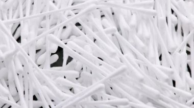 pile of q-tips or cottom buds slowly rotating on black background