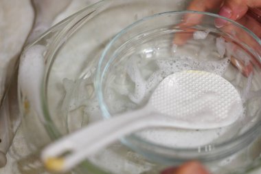 dirty glass kitchenware partially covered with detergent sud in process of hand wahsing