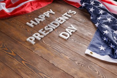 words happy presitdents day laid with real letters on wooden board near US flag