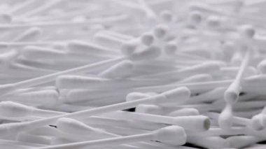 pile of q-tips or cottom buds slowly rotating on black background