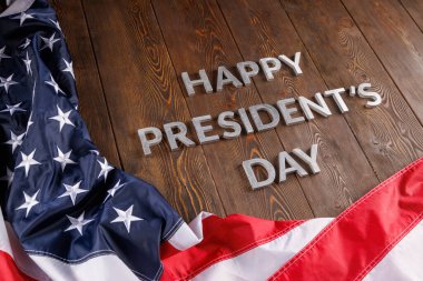 words happy presitdents day laid with real letters on wooden board near US flag