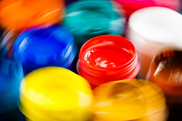 Full-frame close-up view of opened gouache paint jars with natural motion blur — Stockfoto