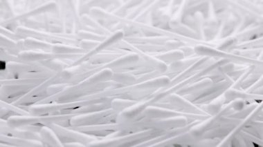 pile of q-tips or cottom buds slowly rotating on black background