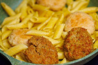 pasta with meatballs in skillet, close-up
