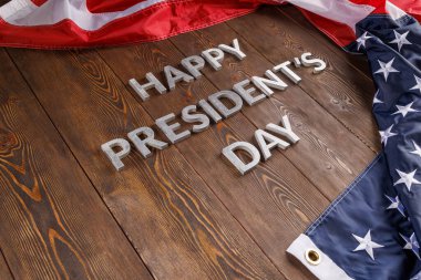 words happy presitdents day laid with real letters on wooden board near US flag