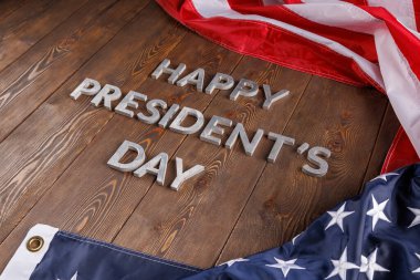 words happy presitdents day laid with real letters on wooden board near US flag