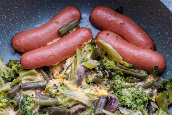 Fried sausages and vegetables with mushrooms and chicken egg on skillet — Stok Foto