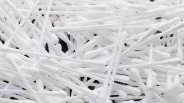 pile of q-tips or cottom buds slowly rotating on black background