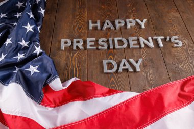 words happy presitdents day laid with real letters on wooden board near US flag