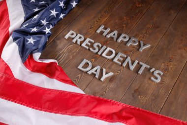 words happy presitdents day laid with real letters on wooden board near US flag