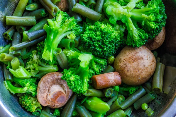 Boiled green vegetables in stainless steel colander - full-frame closeup - Stock-foto