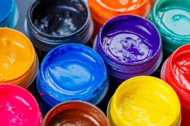 full-frame close-up background of opened small gouache paint jars