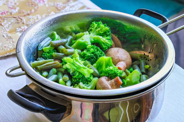 Boiled green vegetables in stainless steel colander - full-frame closeup — Stockfoto