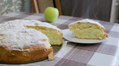 hot classic apple pie and its piece on white plate with steam
