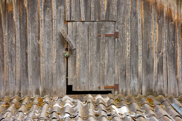 Closed wooden door to an attic in rustic wooden house — Stock Fotó