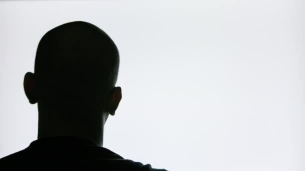 Лисий чоловік в окулярах з бородою рухає голову перед блимаючим екраном — стокове відео