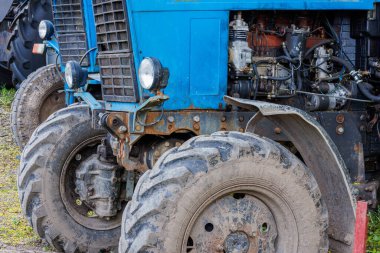 blue belarussian tractors, wheels and opened diesel engine compartments close view