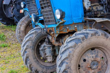 blue belarussian tractors, wheels and opened diesel engine compartment, close view