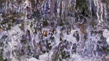 the flowing water small rapid waterfall on river in slow motion at daylight - full-frame background