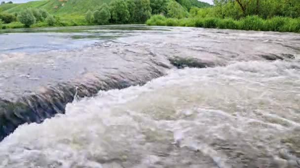 夏の川の流れる水には小さな滝と緑の銀行があり — ストック動画