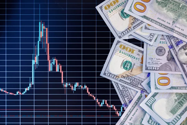 US dollar banknotes stacks over digital screen with exchange chart, depreciation and volatility concept, directly above view