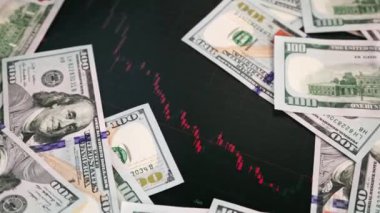 US dollar banknotes stacks over digital screen with exchange chart, depreciation and volatility concept, close-up view