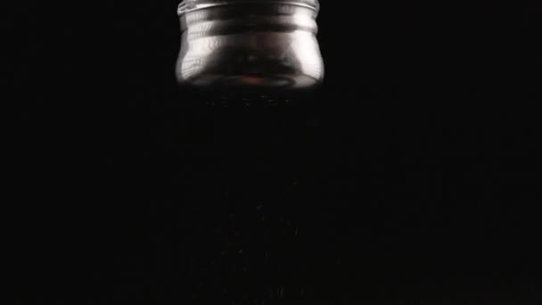 黑胡椒在黑色背景上以慢动作从胡椒壶里掉了出来 — 图库视频影像