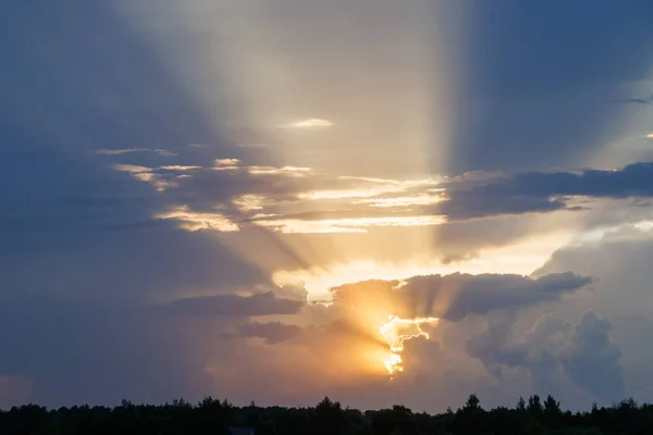 cloudy sunset sky with yellow sun rays with horizon, captured with 105mm lens