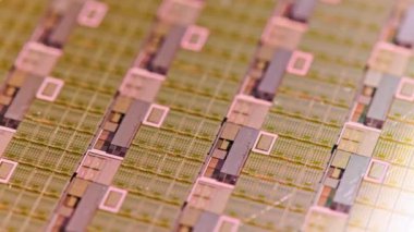 full-frame looped spinning silicone microchip wafer with gold colored chips, real-lofe video footage