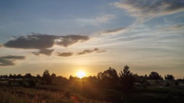 summer wild meadow sunrise time-lapse with green trees and bushes near ravine.