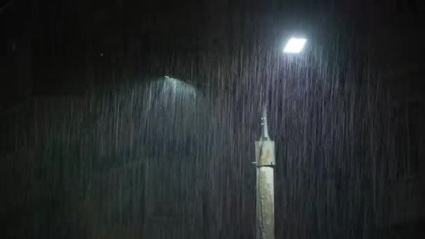 夜间下大雨时 双层铅板灯柱 中等尺寸的雨滴照在灯柱上 明亮的灯光下 静态观点 长雨滴尾为180度快门窗曝光 — 图库视频影像