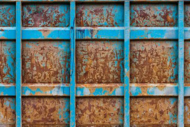 rusted reinforced container wall with leftovers of blue paint, flat full-frame background and texture.